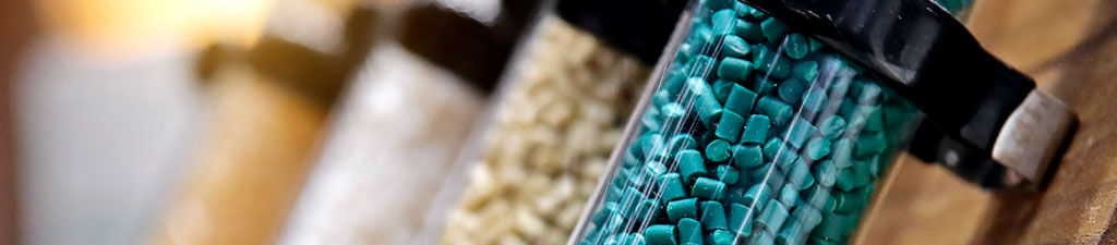 Plastic factory laboratory. Glass flasks with colored dye in granules for plastics.
