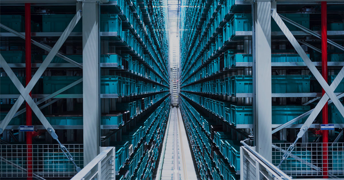 Symmetrical view of a modern automated warehouse with tall shelving and blue bins.