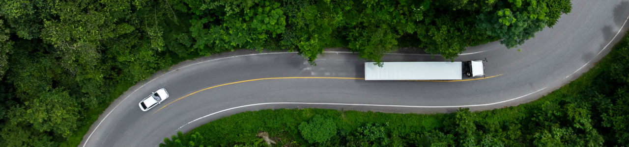 aerial view of a truck on a winding path for article about energy transition in trucking