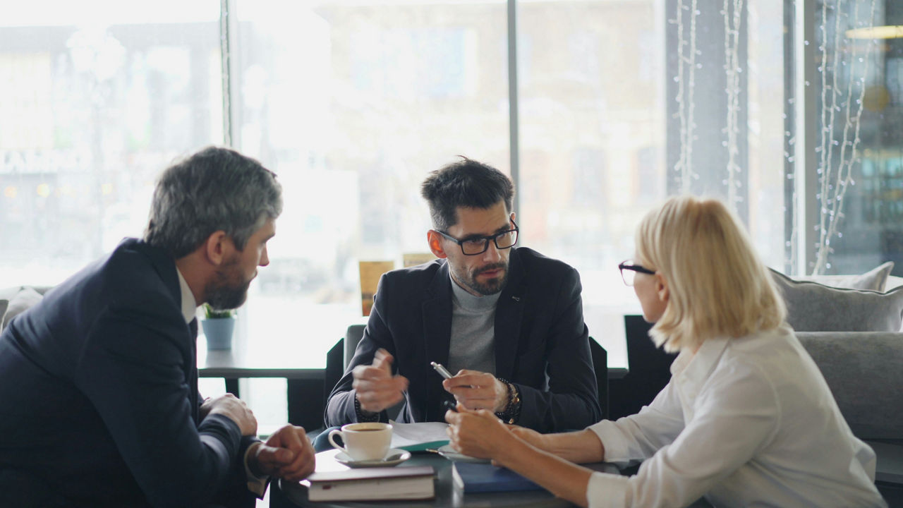 a professional services woman and two men having a meeting